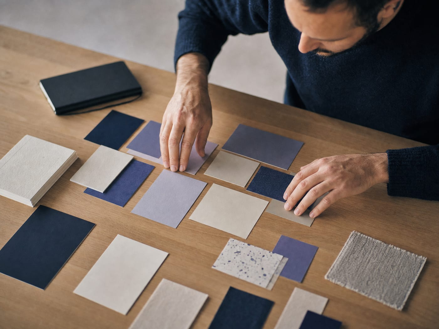 A creative team arranging layout sheets and colour direction on a table